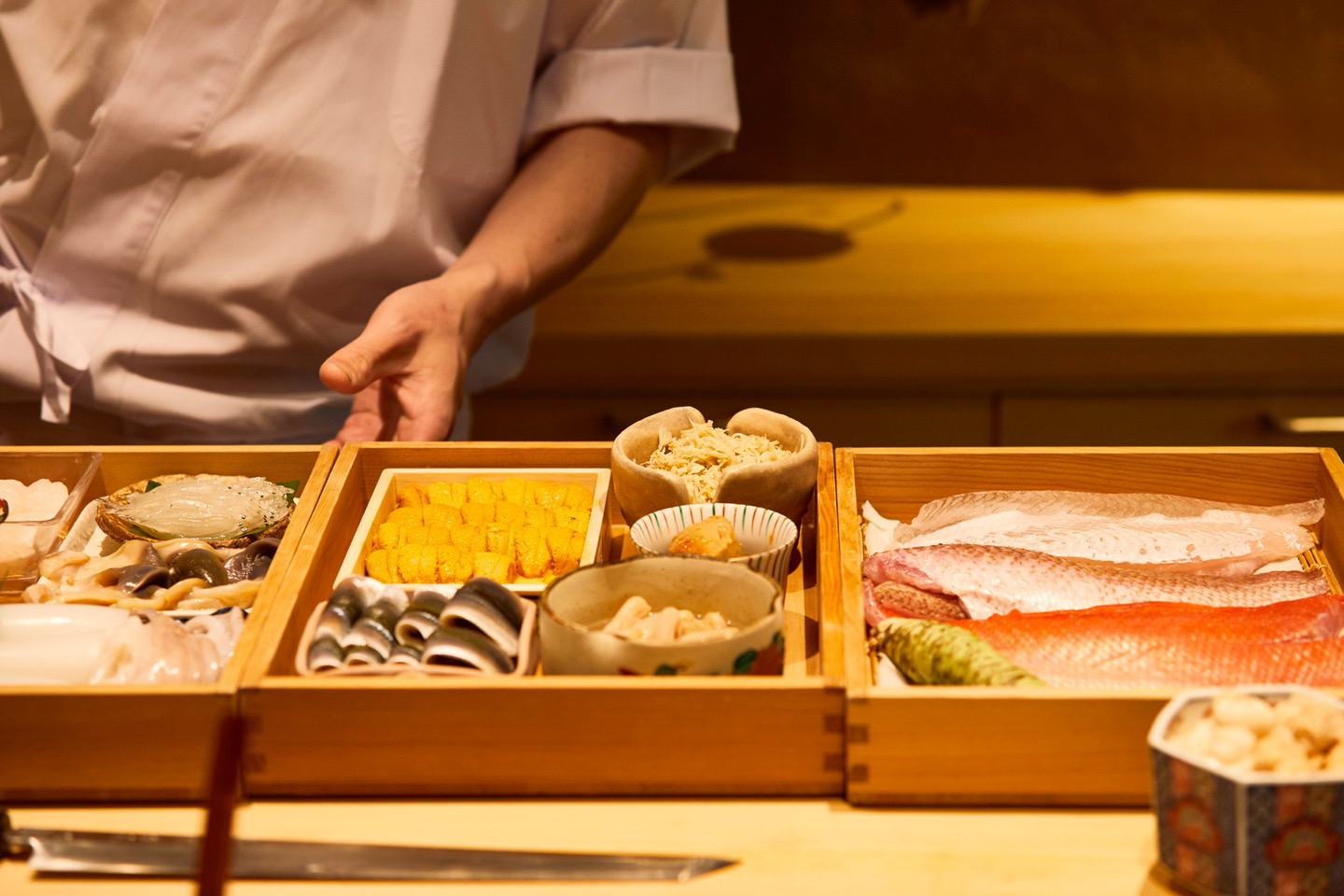 木箱に並べた食材と料理人の手元